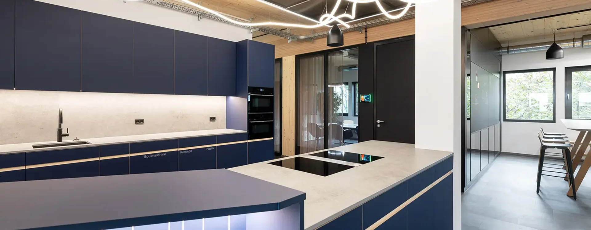 Hochwertige Innenarchitektur in Stuttgart mit einer modernen Büro-Küchenzeile, minimalistischer Einrichtung und gemütlicher Sitzecke