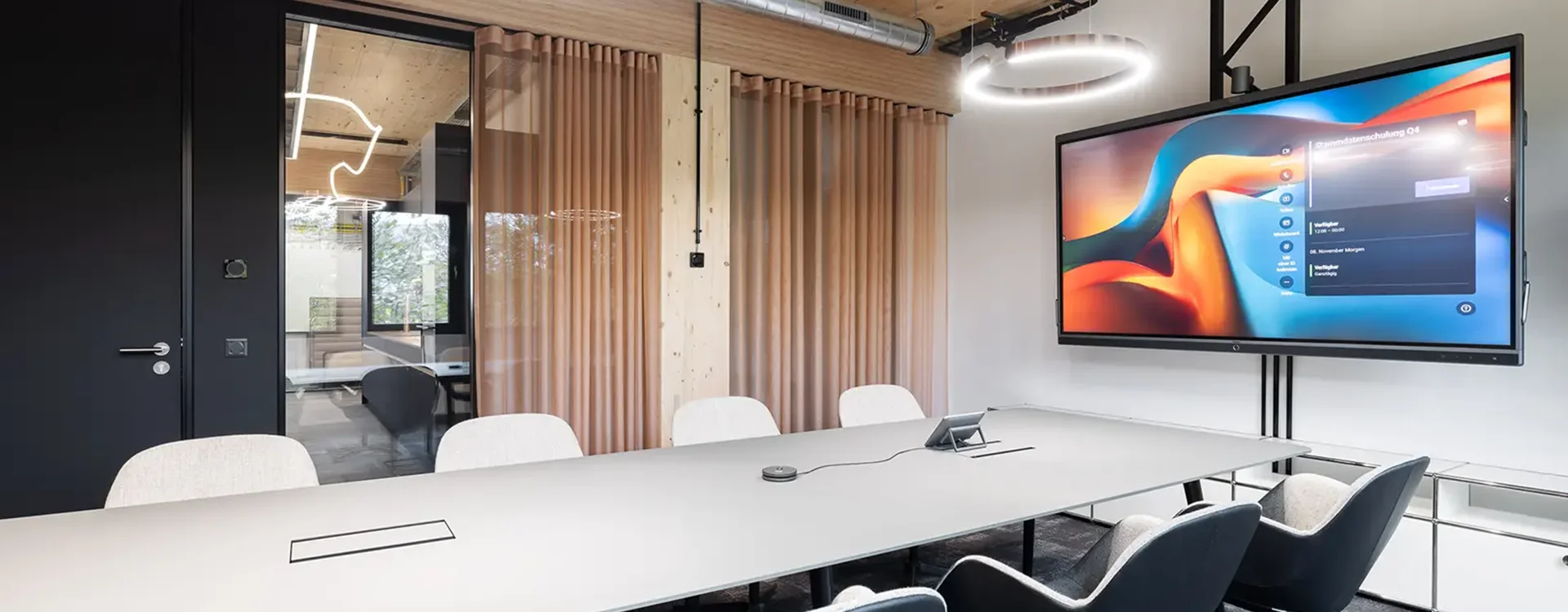 Ein Besprechungsraum in Augsburg mit interaktivem Bildschirm, eleganter Einrichtung und modernen Stühlen, perfekt für Meetings und Präsentationen.