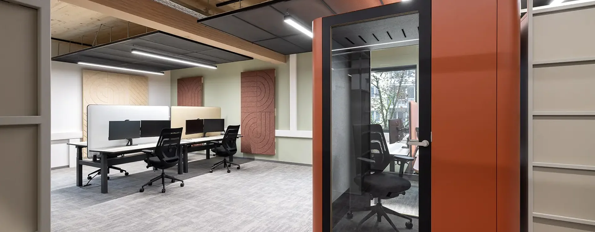 Innovativer Workspace in Berlin mit schallgeschützter Telefonbox, offenen Arbeitsplätzen und einer modernen Lichtgestaltung